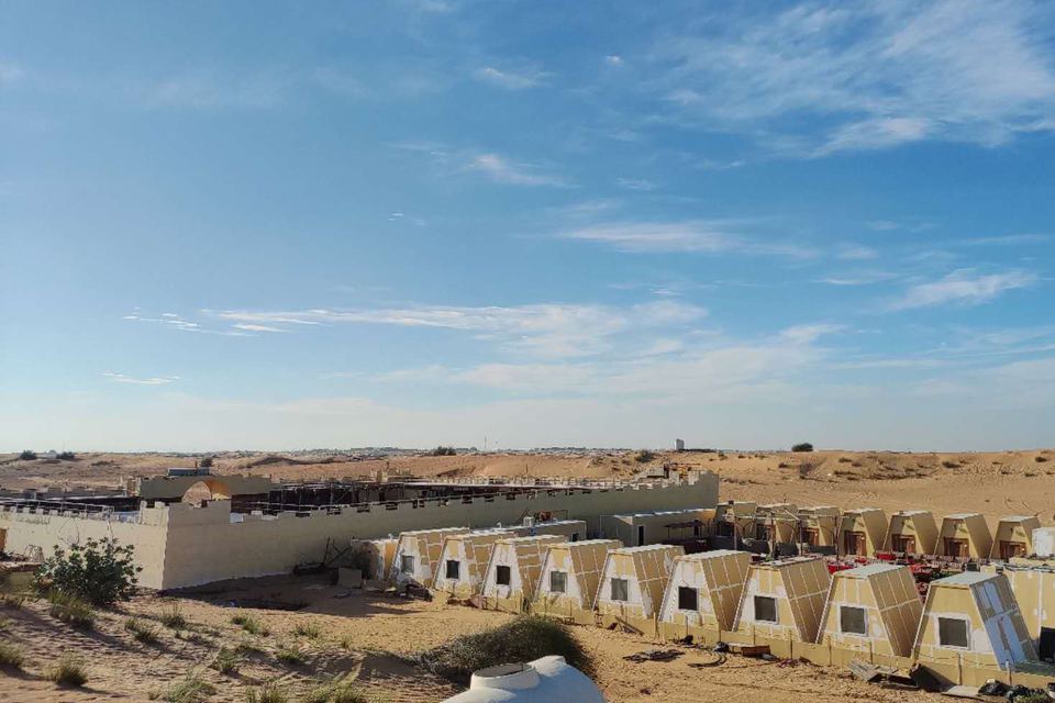 The group’s desert camp: rows of tent-shaped cabins inside a walled compound among the dunes